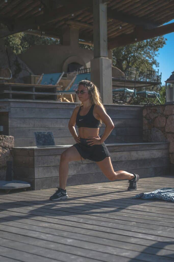 A young woman stretching before a run to help her run faster.